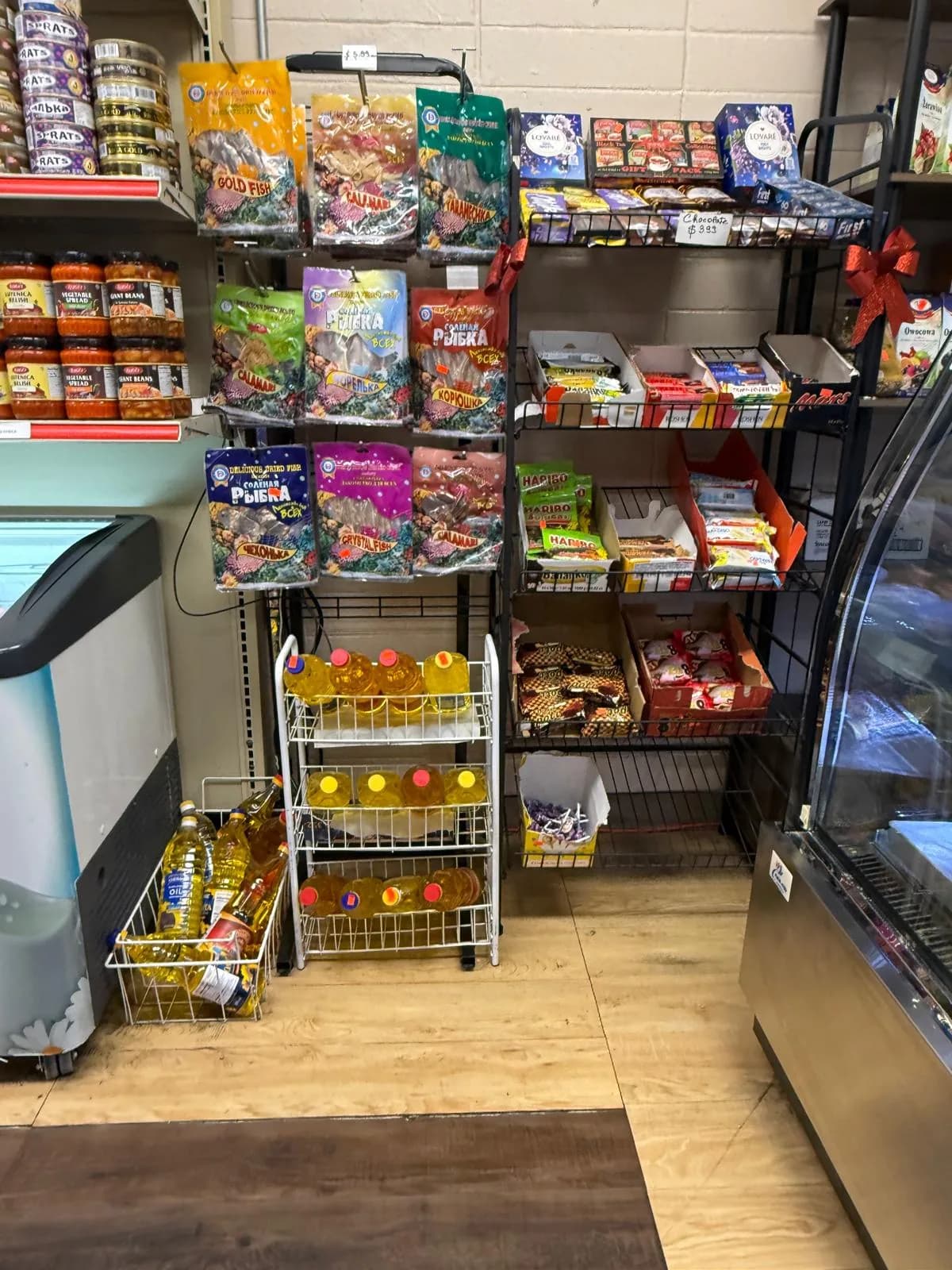 Snack racks and refrigerated cases along a market aisle
