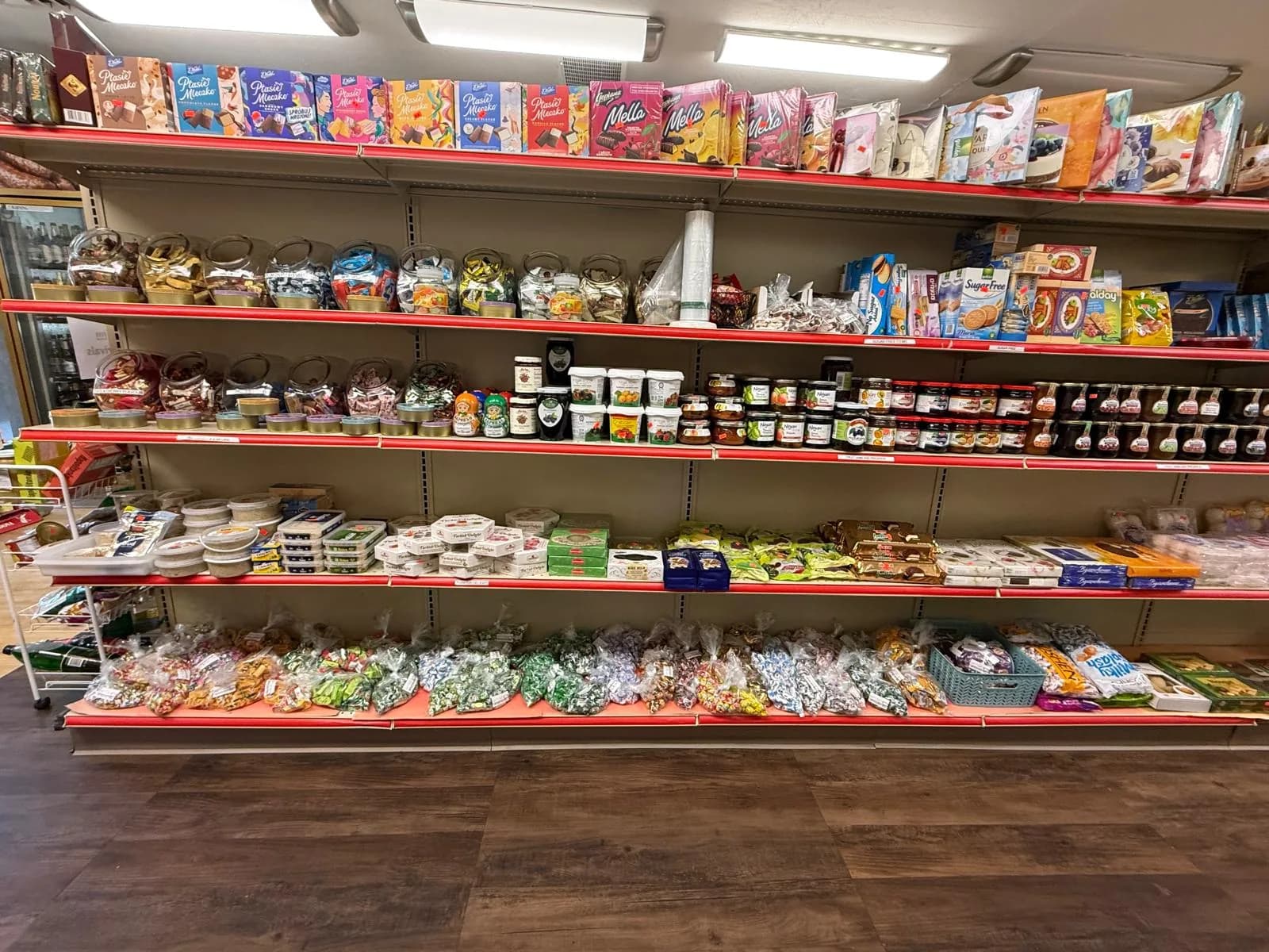 A wide view of the market floor with the deli counter and stocked shelves